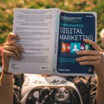 Person reading Digital Marketing book.