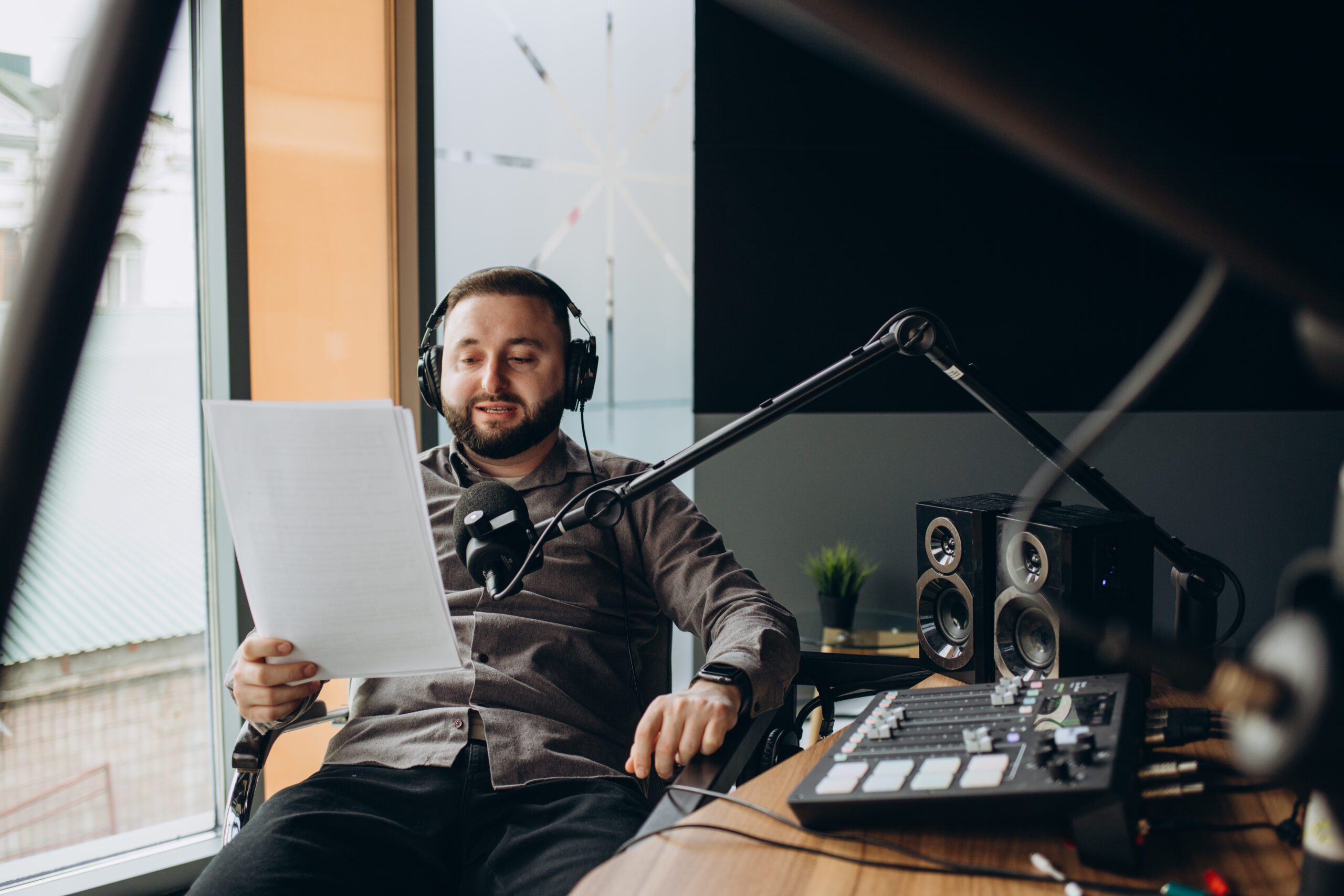 Portrait of happy young man working as radio host at radio station.