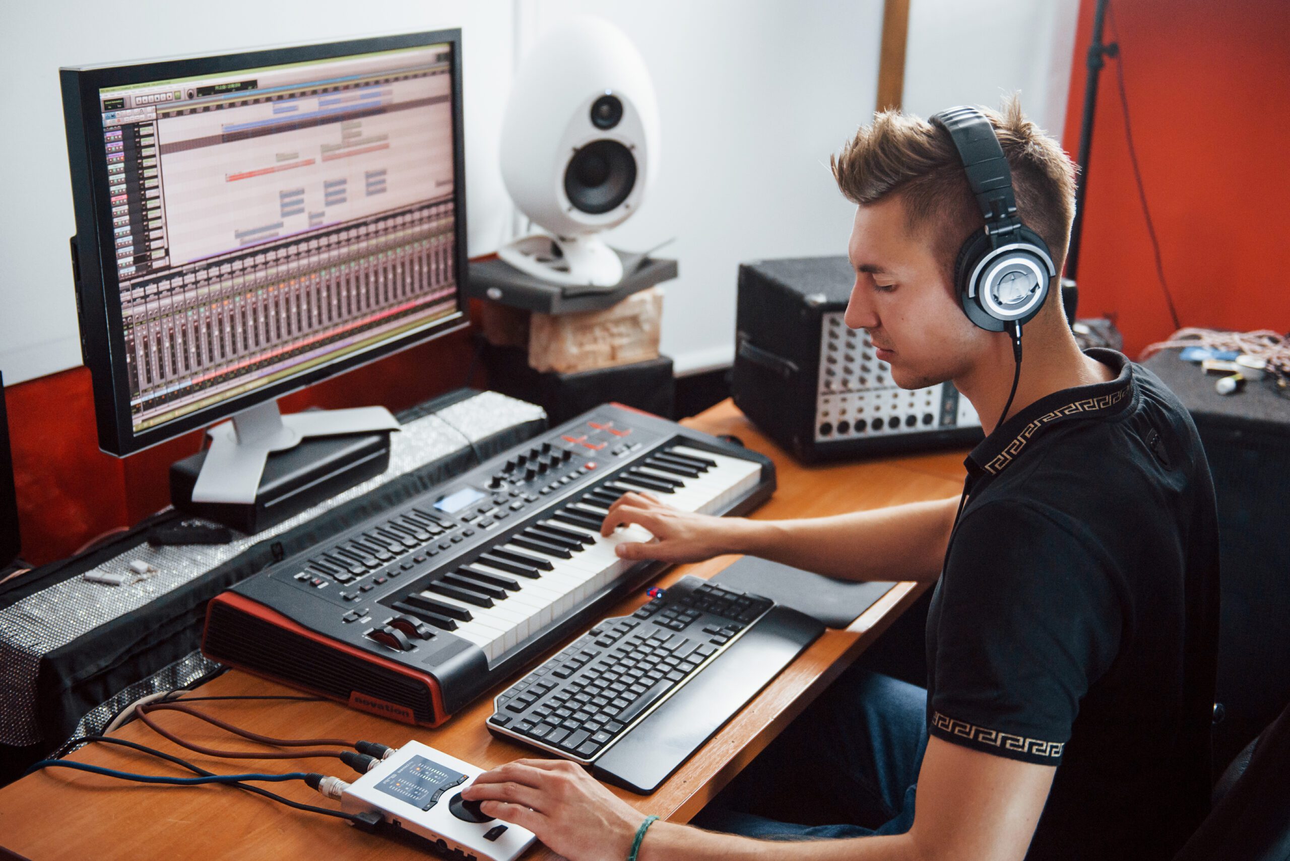 Sound engineer in headphones working and mixing music indoors in the studio.